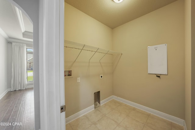 laundry area featuring hookup for a washing machine, ornamental molding, a textured ceiling, and hookup for an electric dryer