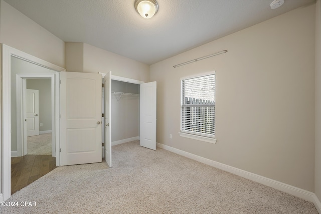 unfurnished bedroom featuring light carpet and a closet