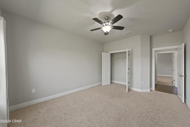 unfurnished bedroom featuring ceiling fan, a closet, and carpet floors