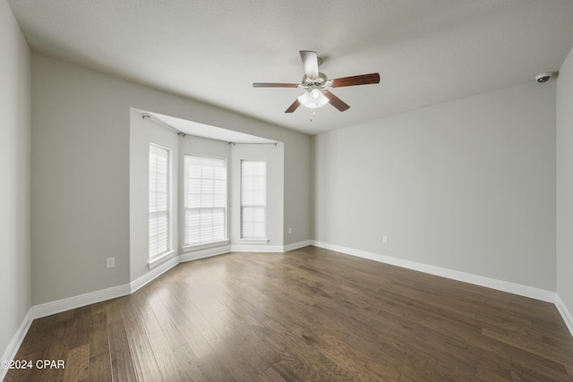 unfurnished room featuring ceiling fan and dark hardwood / wood-style flooring