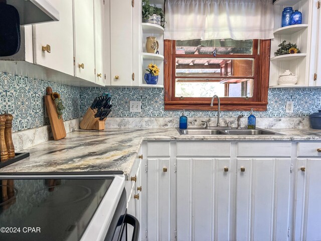 kitchen featuring tasteful backsplash, white cabinetry, sink, exhaust hood, and light stone counters