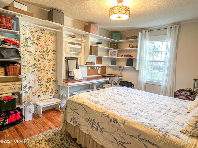 bedroom featuring hardwood / wood-style flooring and a textured ceiling