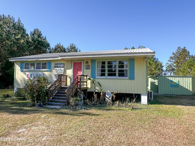 view of front of property with central AC unit and a front yard