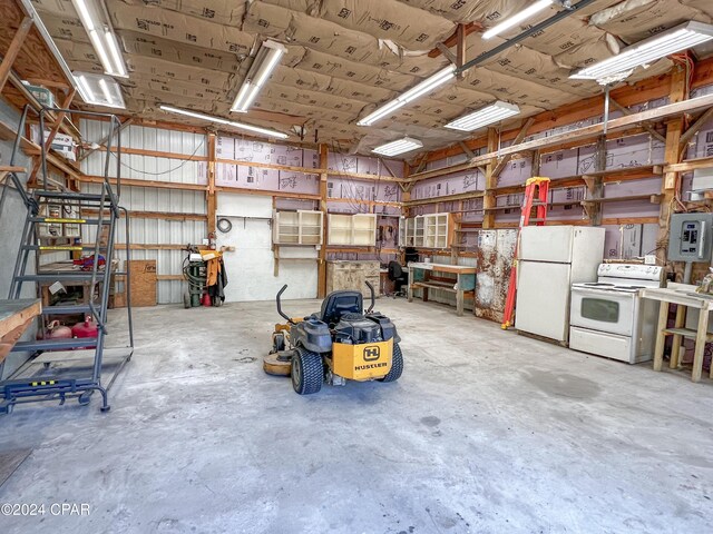 garage with a workshop area, electric panel, and white fridge