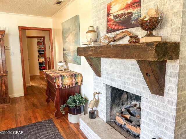 interior space featuring crown molding, wood-type flooring, and a textured ceiling