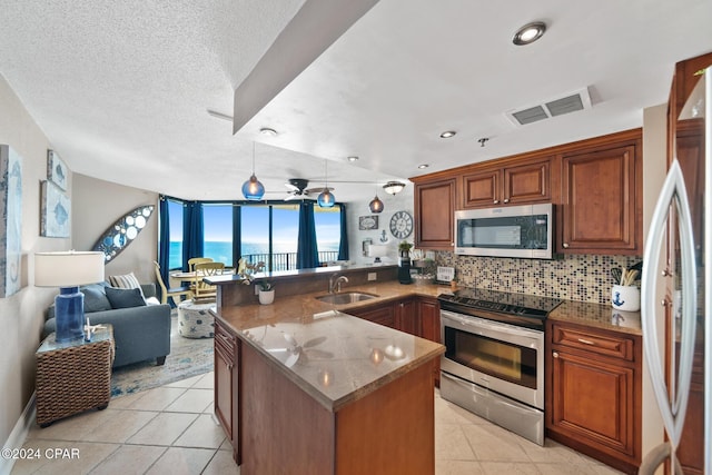 kitchen with stainless steel appliances, tasteful backsplash, sink, kitchen peninsula, and light tile patterned floors