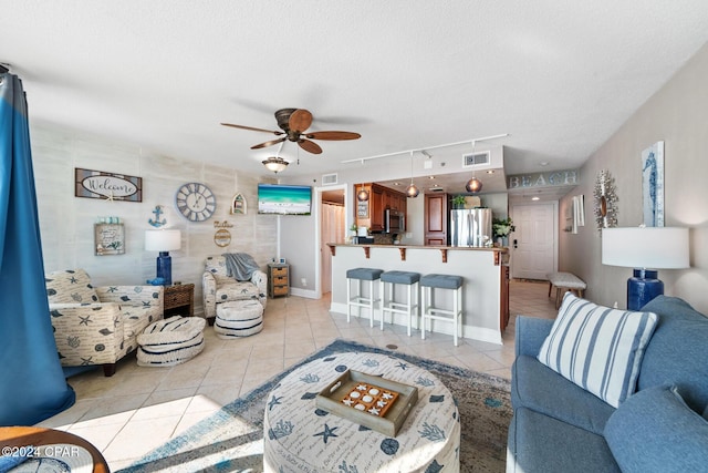 tiled living room featuring ceiling fan and a textured ceiling