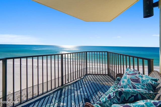 balcony with a water view and a view of the beach