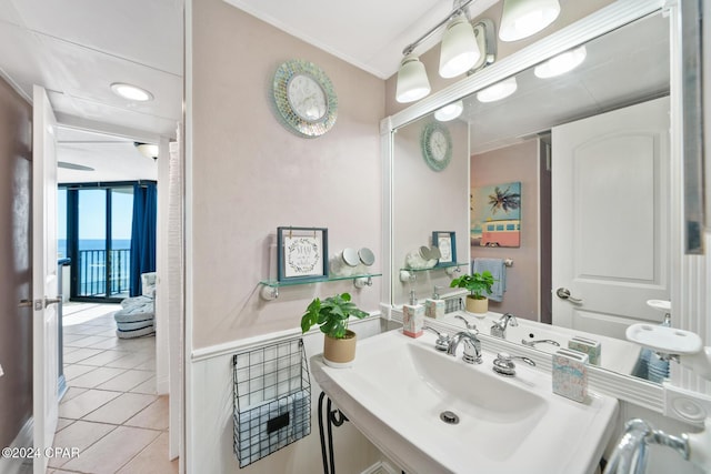 bathroom featuring ornamental molding, tile patterned flooring, expansive windows, and vanity