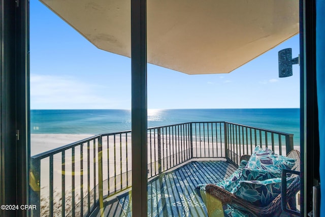 balcony with a water view and a view of the beach