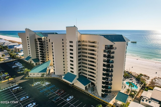 view of building exterior with a beach view and a water view