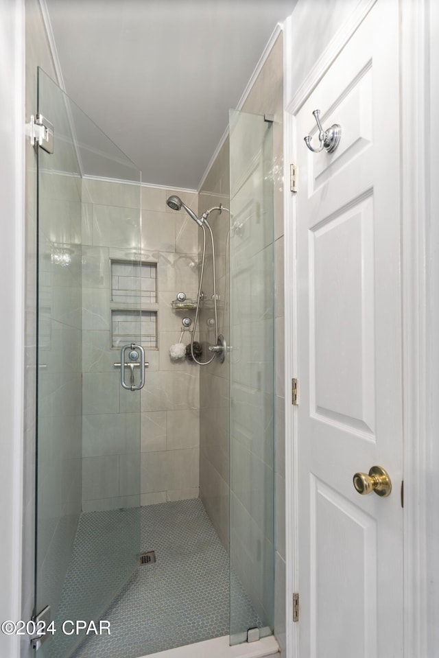 bathroom featuring crown molding and an enclosed shower