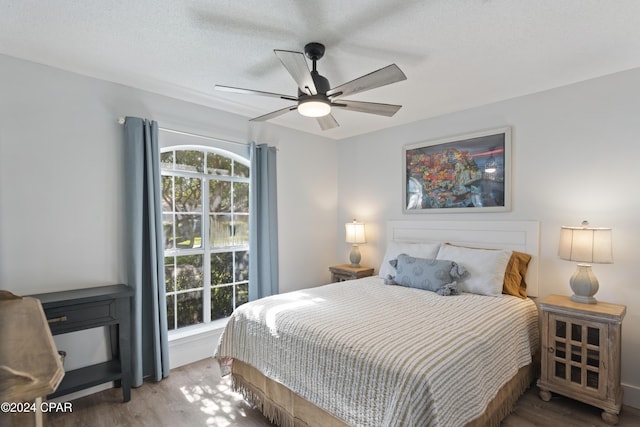 bedroom featuring a textured ceiling, ceiling fan, and wood-type flooring