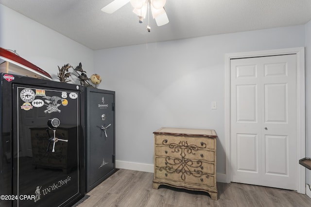 interior space with ceiling fan, light wood-type flooring, and a textured ceiling