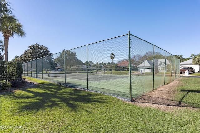 view of tennis court with a yard