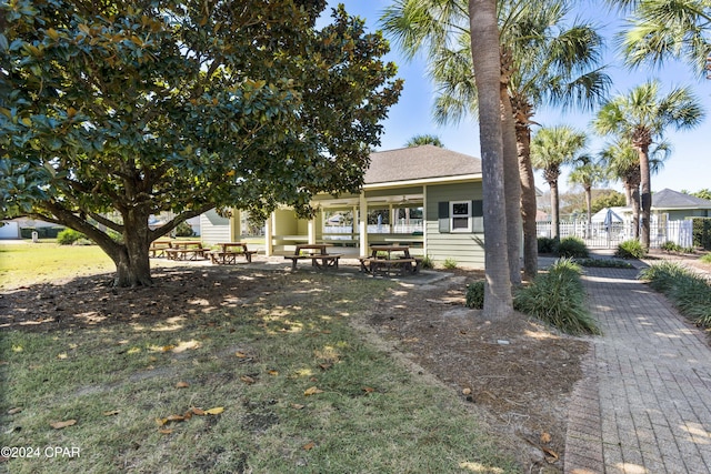 view of property hidden behind natural elements featuring a front lawn