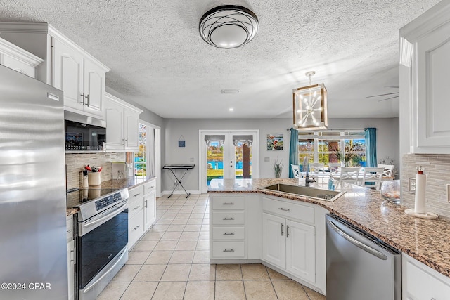 kitchen with french doors, sink, appliances with stainless steel finishes, white cabinets, and backsplash