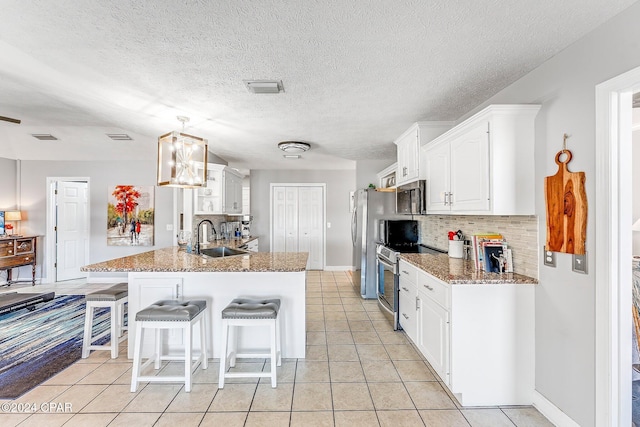 kitchen featuring sink, appliances with stainless steel finishes, backsplash, white cabinets, and kitchen peninsula