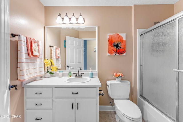 full bathroom with tile patterned flooring, vanity, shower / bath combination with glass door, and toilet