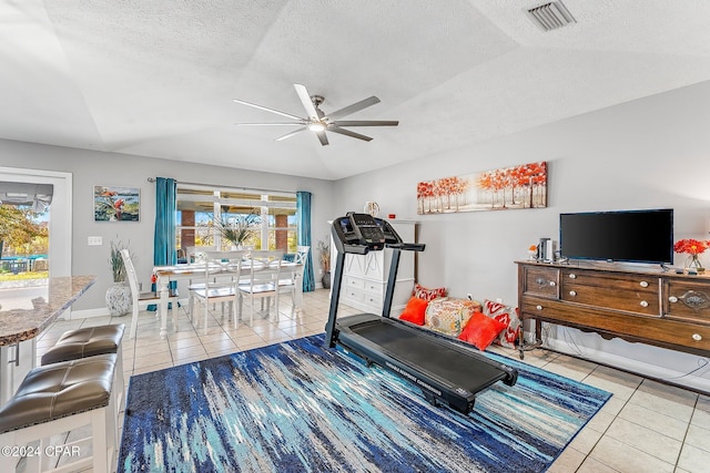 workout room with light tile patterned floors, a textured ceiling, and ceiling fan