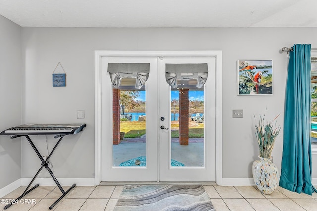 doorway to outside with light tile patterned floors and french doors