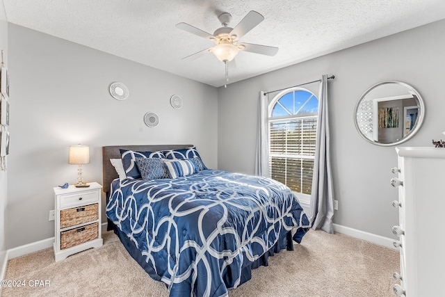 carpeted bedroom with a textured ceiling and ceiling fan