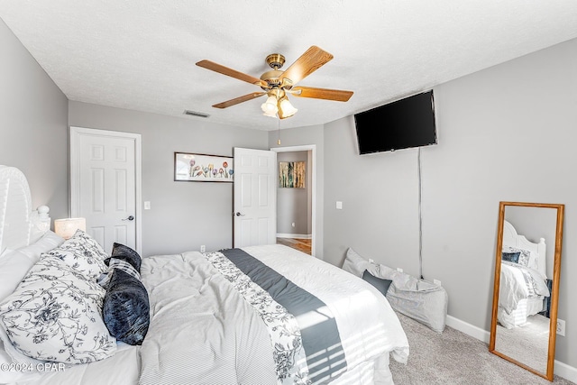 bedroom with carpet, a textured ceiling, and ceiling fan