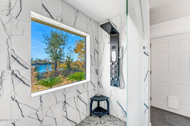 interior space with a textured ceiling and a shower