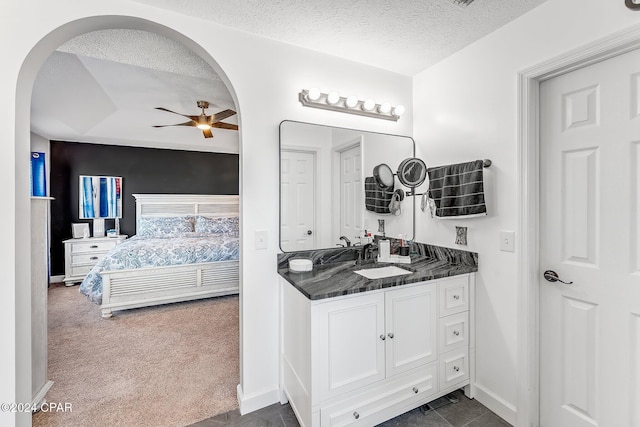 bathroom featuring ceiling fan, vanity, and a textured ceiling