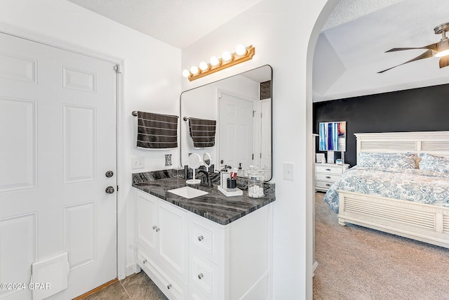 bathroom featuring ceiling fan, vanity, and a textured ceiling