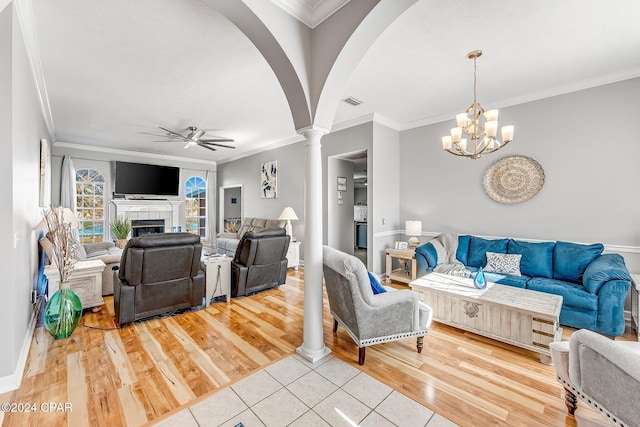 living room featuring hardwood / wood-style flooring, ornamental molding, and ceiling fan with notable chandelier