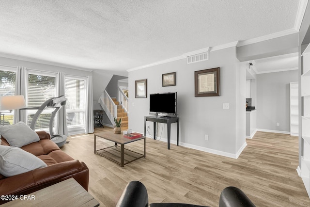 living area featuring crown molding, visible vents, light wood-style flooring, a textured ceiling, and stairs