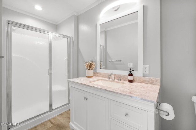 full bath featuring ornamental molding, a stall shower, wood finished floors, and vanity