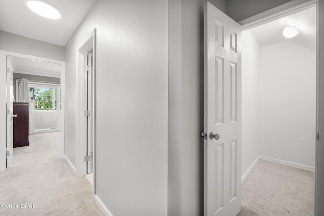 corridor with light carpet and baseboards