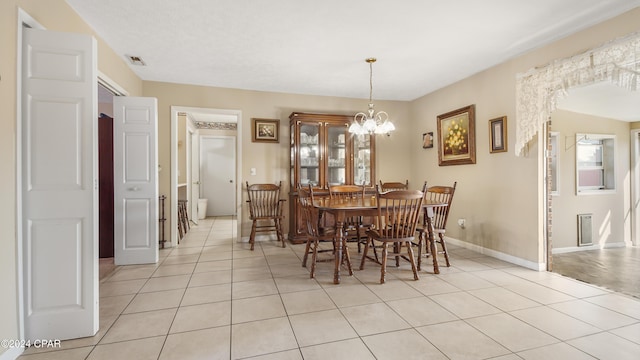 dining room with light tile patterned floors and a chandelier