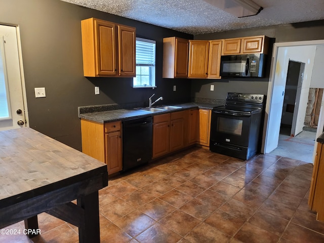 kitchen with a textured ceiling, sink, and black appliances