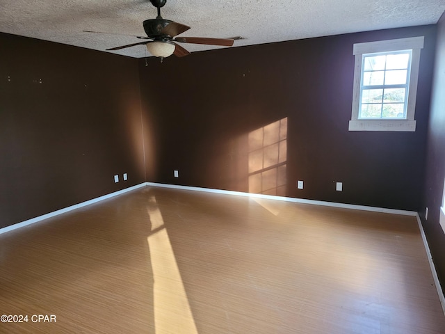 spare room with hardwood / wood-style floors, a textured ceiling, and ceiling fan