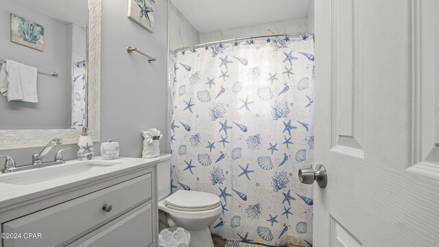 bathroom with walk in shower, vanity, and toilet