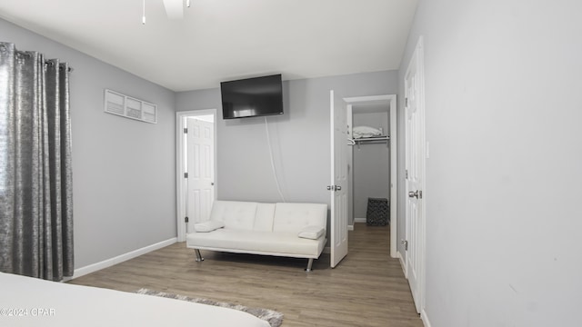 bedroom featuring ceiling fan, a closet, hardwood / wood-style floors, and a spacious closet