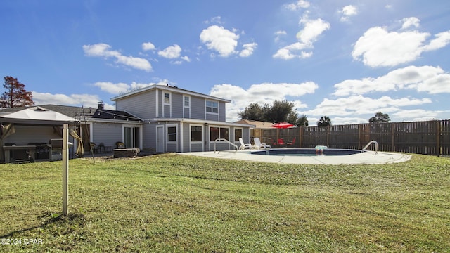 back of house with a yard, a patio, and a fenced in pool