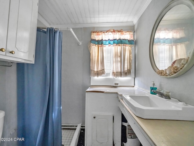 bathroom featuring curtained shower, ornamental molding, and sink