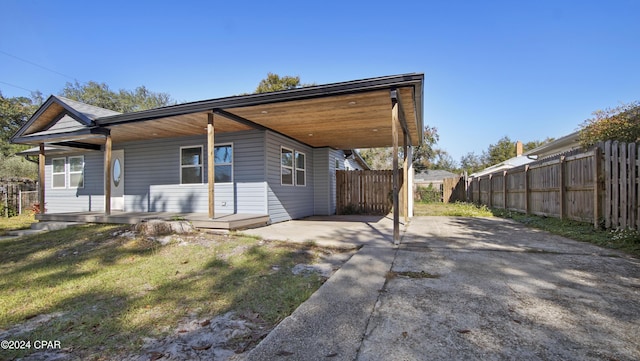 view of front of property featuring covered porch, a front yard, and a carport