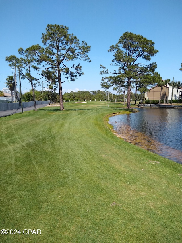 view of home's community with a lawn and a water view