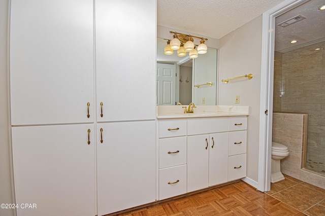 bathroom featuring a textured ceiling, parquet flooring, toilet, walk in shower, and vanity