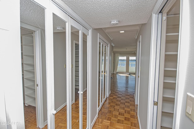 hallway featuring dark parquet flooring and a textured ceiling