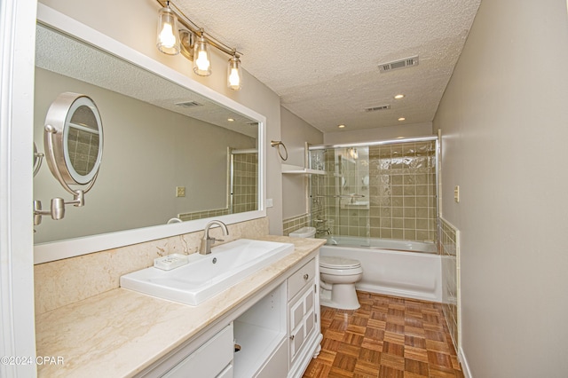 full bathroom with parquet floors, toilet, vanity, shower / bath combination with glass door, and a textured ceiling