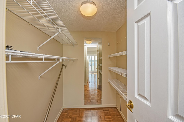 walk in closet with parquet floors