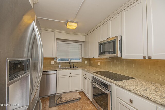 kitchen with sink, stainless steel appliances, white cabinets, and decorative backsplash