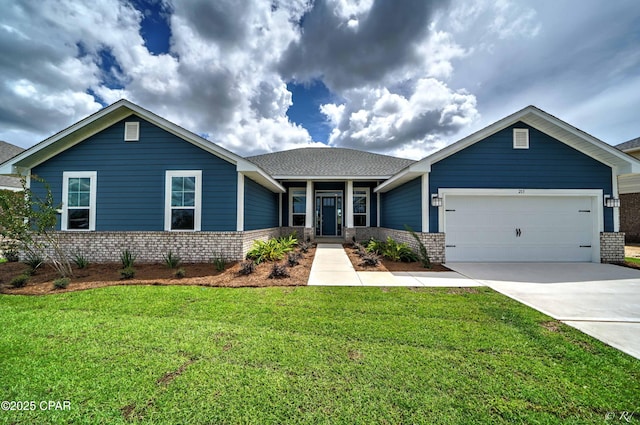 view of front of house featuring a front yard, a garage, brick siding, and driveway