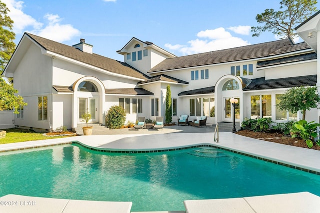 back of property with outdoor lounge area and a patio